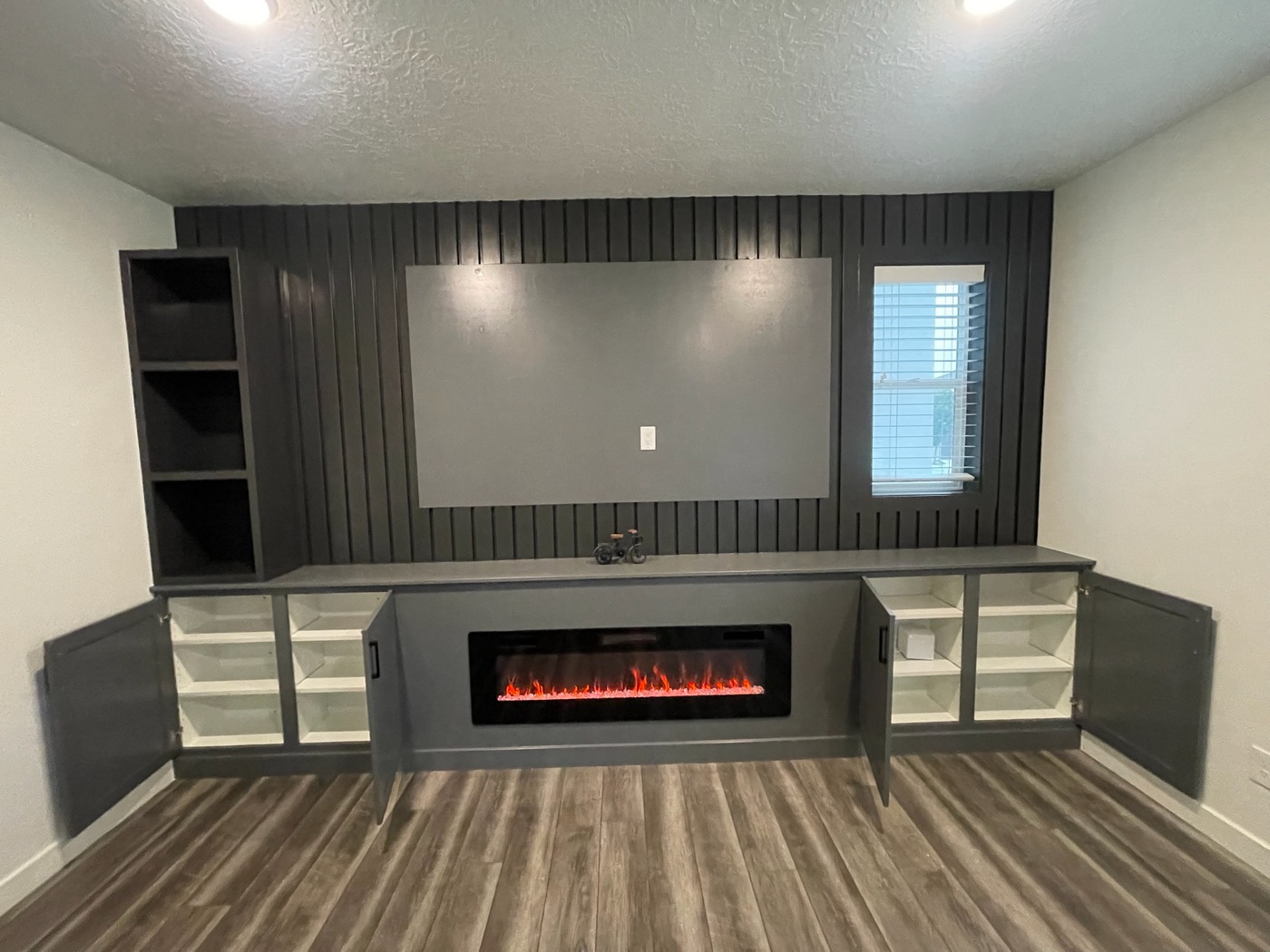 Built-in media wall with electric fireplace and slatted panel